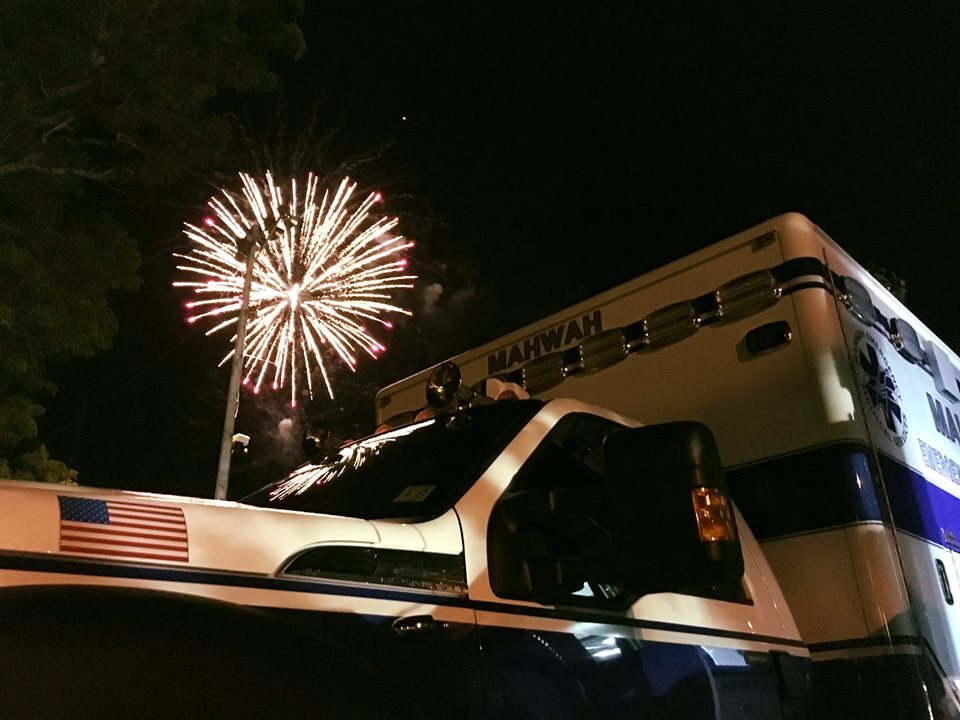 Mahwah EMS ambulance standing by beneath fireworks